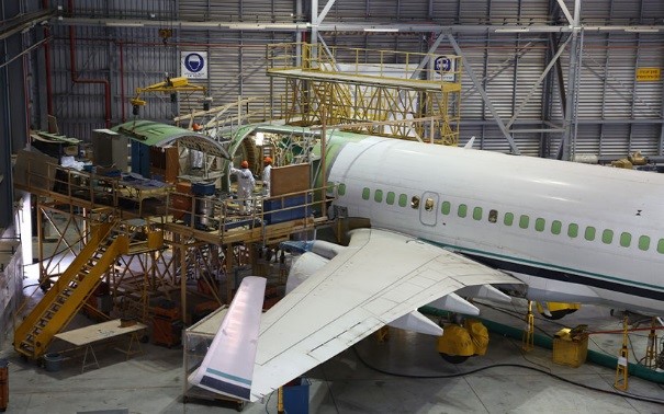 Photograph of a passenger aircraft undergoing structural modification in a hangar for a passenger-to-freighter conversion program